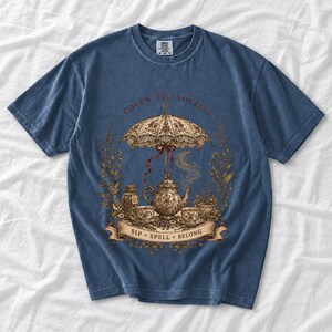 Vintage poster style ornate teapot with crescent moon steam, teacups and herbs, text Coven Tea Society
