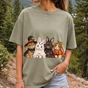 Realistic illustration of four bunnies in witch, ghost, vampire cape and pumpkin costumes in a row