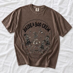 Skeleton bride popping champagne with cheering skeleton bridesmaids and the text Bride & Boo Crew