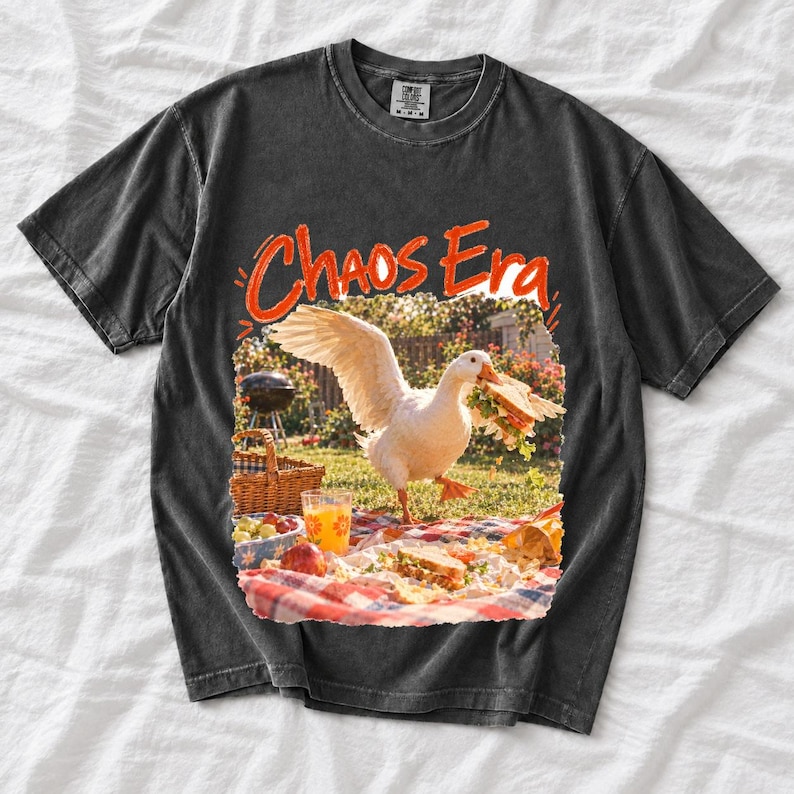 Goose stealing a sandwich from a picnic blanket, 90s film photo style, text "Chaos Era"
