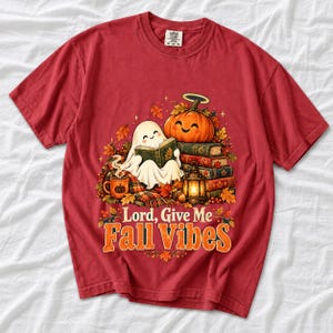 Smiling pumpkin with a halo beside a stack of books and a lantern, text "Lord, Give Me Fall Vibes", retro fall illustration