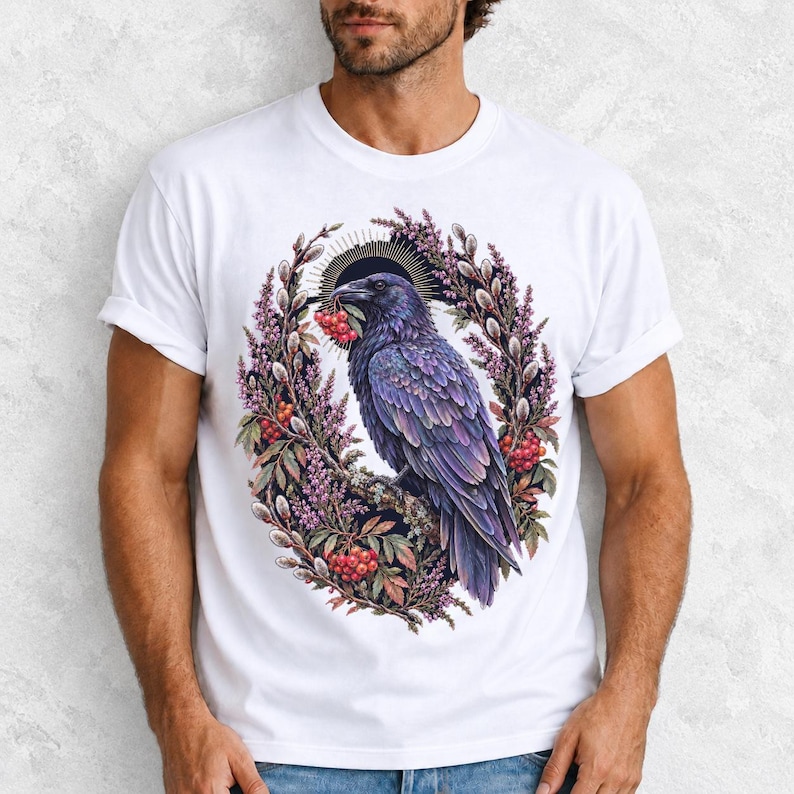 Raven holding a rowan berry inside an oval wreath of heather and catkins, painted cottagecore bird illustration