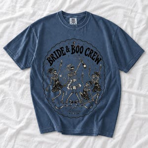Skeleton bride popping champagne with cheering skeleton bridesmaids and the text Bride & Boo Crew