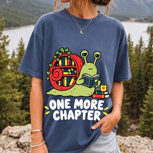 Cartoon snail reading a book with a bookshelf shell and the text One More Chapter