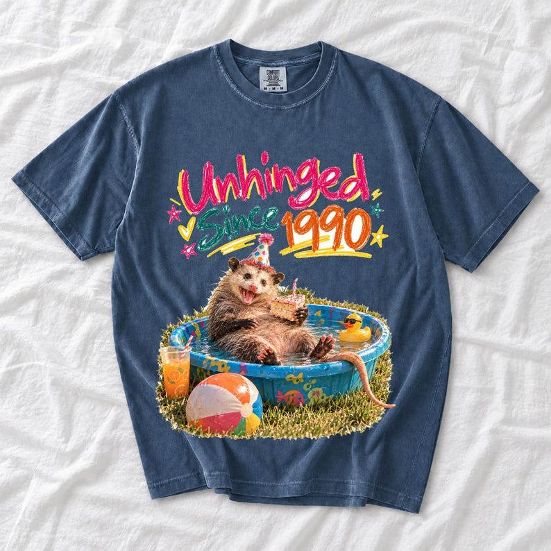 Opossum in party hat in a kiddie pool with cake, 90s film photo style, text "Unhinged Since 1990"