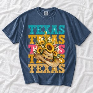 Straw cowboy hat full of sunflowers over a five-line stacked TEXAS word in retro western colors