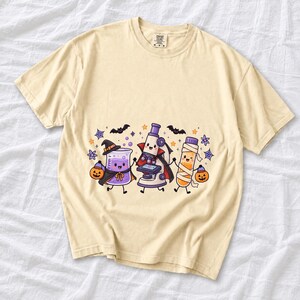 Kawaii beaker, microscope and test tube with faces in Halloween costumes, pastel purple and orange