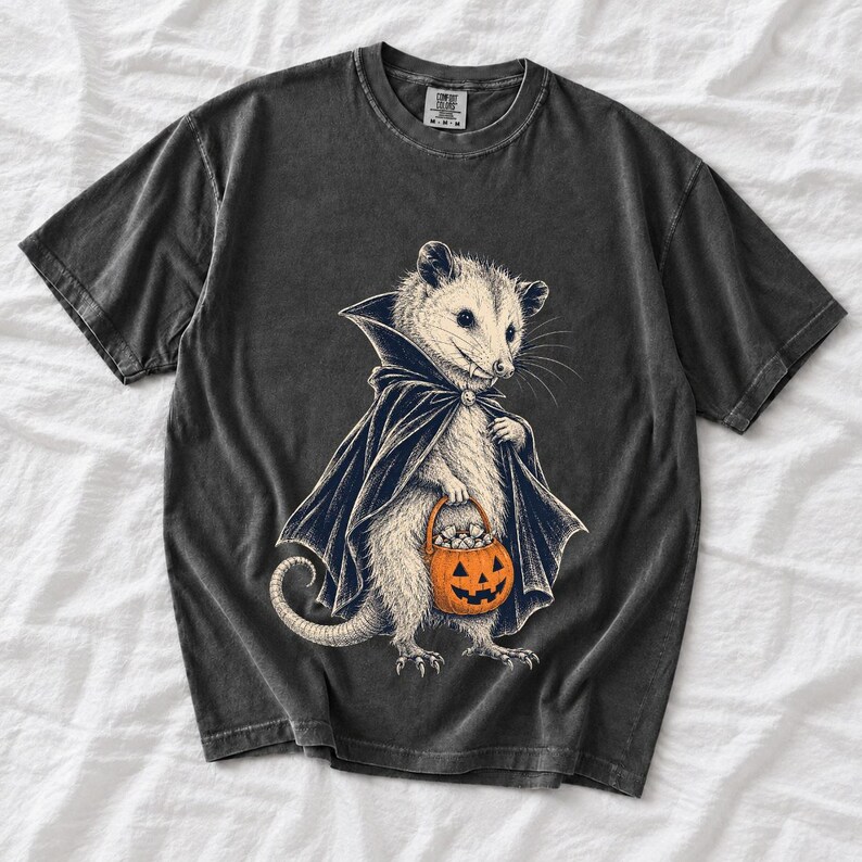 Etched pen illustration of an opossum in a vampire cape holding a candy pumpkin, bone white with orange accent