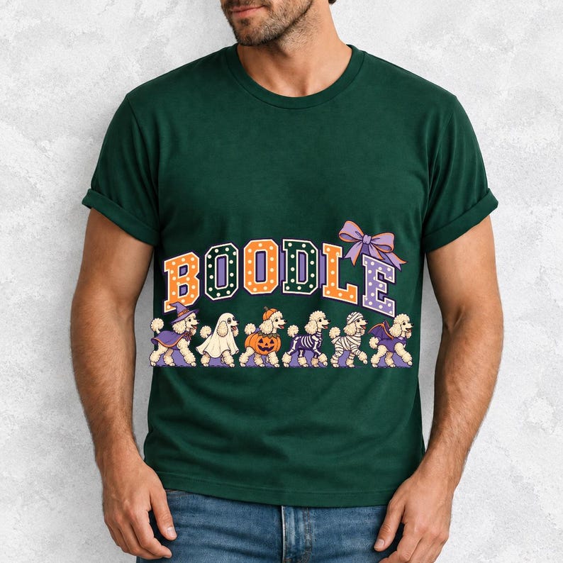 Six poodles in Halloween costumes walking under the arched word BOODLE, lavender and orange polka-dot varsity style