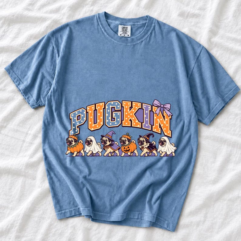 Six pugs in pumpkin, ghost and witch costumes under the arched word PUGKIN, lavender and orange polka-dot varsity style