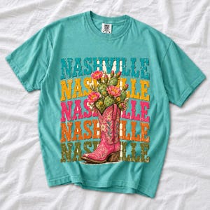 Pink embroidered cowboy boot with blooming cactus over a five-line stacked NASHVILLE word in retro colors