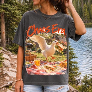 Goose stealing a sandwich from a picnic blanket, 90s film photo style, text "Chaos Era"