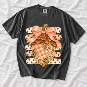 Giant patchwork acorn with a pink satin bow made of plaid, leopard and floral fabric on polka-dot stripes