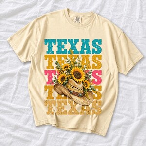 Straw cowboy hat full of sunflowers over a five-line stacked TEXAS word in retro western colors