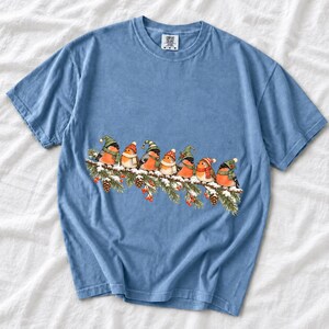 Watercolor bullfinches and robins in elf hats and scarves on a snowy pine branch