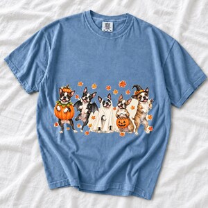 Five watercolor Boston terriers in Halloween costumes with falling autumn leaves