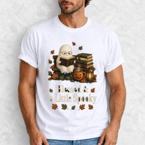 Cute ghost with glasses reading a Bible with a candle and mug, text "Blessed & a Little Spooky", retro fall illustration