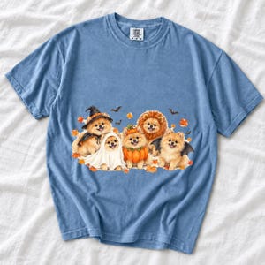 Five fluffy watercolor pomeranians in Halloween costumes with autumn leaves and bats