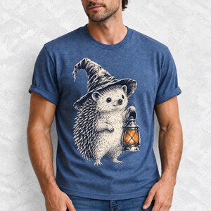 Etched pen illustration of a hedgehog in a witch hat holding a lantern, bone white with orange accent