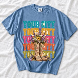 Tan cowboy boots with lavender and wildflowers over a five-line stacked personalized city word in retro colors