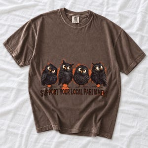 Four fluffy big-eyed black owls in a row with the text "Support Your Local Parliament"