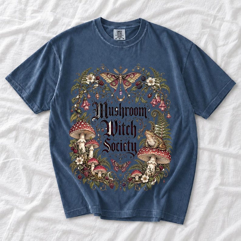 Blackletter text "Mushroom Witch Society" framed by fly agaric mushrooms, ferns and a toad on a mushroom cap