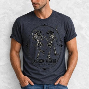 Two cowgirl skeletons in hats line dancing in a starry frame with the text Last Rodeo Nashville