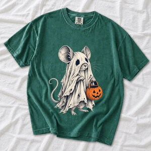 Etched pen illustration of a small mouse in a sheet ghost costume holding a candy bucket, bone white with orange accent