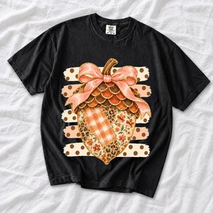 Giant patchwork acorn with a pink satin bow made of plaid, leopard and floral fabric on polka-dot stripes