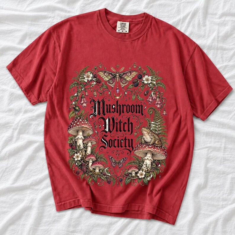 Blackletter text "Mushroom Witch Society" framed by fly agaric mushrooms, ferns and a toad on a mushroom cap