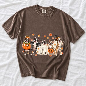Five watercolor Boston terriers in Halloween costumes with falling autumn leaves