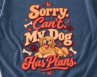 May include: A blue t-shirt featuring a graphic of a golden retriever lying down. The text reads Sorry, Can't, My Dog, Has Plans. The design includes red and cream-colored lettering, small red hearts, white dog bones, and red paw prints.