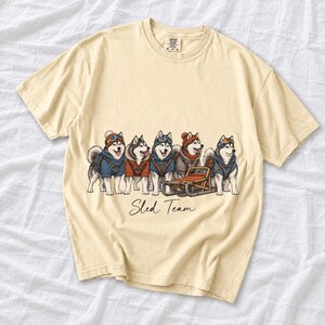 Illustrated huskies in ski gear lined up with a sled, text Sled Team