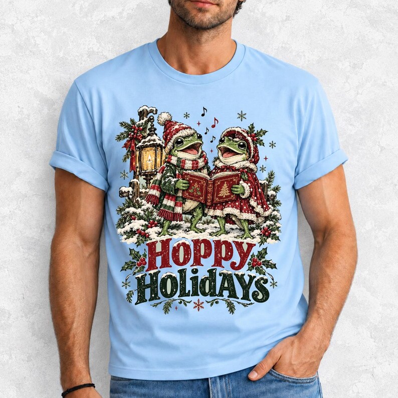 Two frogs singing carols in the snow with a lantern and songbook, text Hoppy Holidays