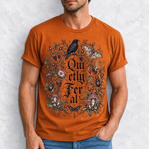Raven on a wild rose branch with beetles and berries around blackletter text "Quietly Feral"