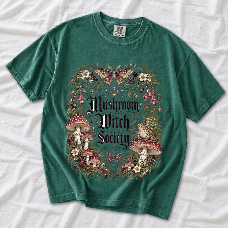 Blackletter text "Mushroom Witch Society" framed by fly agaric mushrooms, ferns and a toad on a mushroom cap