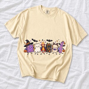 Kawaii books, pencil and bookmark with faces in Halloween costumes, pastel purple and orange