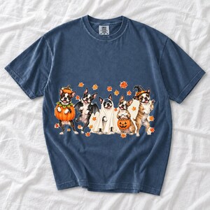 Five watercolor Boston terriers in Halloween costumes with falling autumn leaves