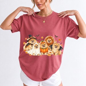 Five fluffy watercolor pomeranians in Halloween costumes with autumn leaves and bats