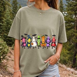 Seven neon highlighter markers with faces in witch, ghost, pumpkin and vampire costumes under bats and stars