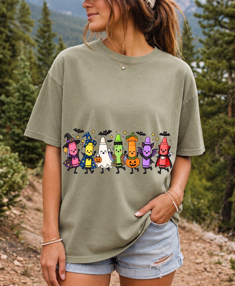 Seven neon highlighter markers with faces in witch, ghost, pumpkin and vampire costumes under bats and stars