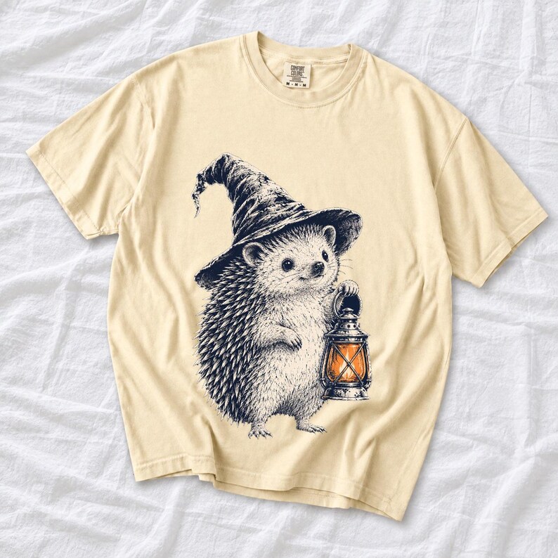 Etched pen illustration of a hedgehog in a witch hat holding a lantern, bone white with orange accent