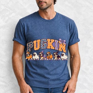 Six pugs in pumpkin, ghost and witch costumes under the arched word PUGKIN, lavender and orange polka-dot varsity style