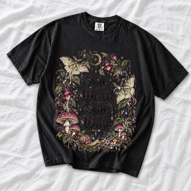 Victorian-style wreath of nightshade, luna moths and toadstools around the words "Stay Weird, Stay Wild"