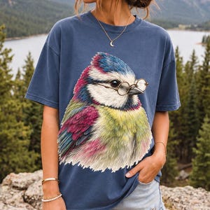 Colored-pencil blue tit bird wearing tiny round reading glasses, funny birdwatcher t-shirt illustration