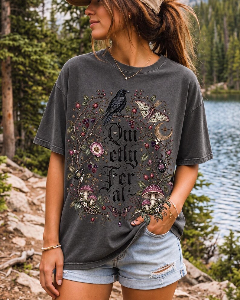 Raven on a wild rose branch with beetles and berries around blackletter text "Quietly Feral"
