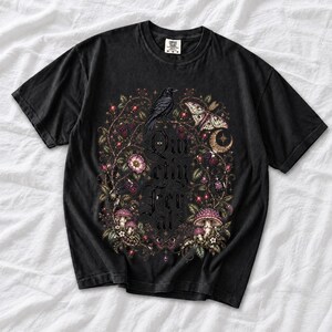 Raven on a wild rose branch with beetles and berries around blackletter text "Quietly Feral"