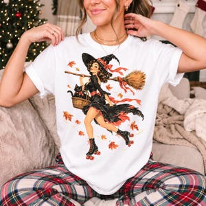 Retro 1950s pin-up witch on roller skates with a broom and a cat in a basket, autumn leaves
