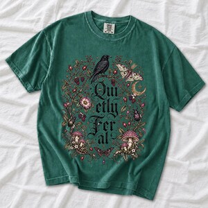 Raven on a wild rose branch with beetles and berries around blackletter text "Quietly Feral"