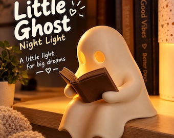 Könnte beinhalten: Ein cremefarbenes, geisterförmiges Nachtlicht mit leuchtend gelben Augen, das ein kleines braunes Buch hält. Der Text lautet: Little Ghost Night Light, A little light for big dreams. Die Lampe steht auf einer Holzoberfläche mit einem warmen Licht.